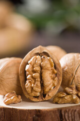 Walnut kernels and whole walnuts on wooden table.