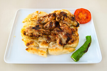 Turkish and Arabic Traditional Ramadan doner kebab with tasty tomato sauce and rice or turkish pilav in white plate on wood table background. ( Pilav ustu doner)