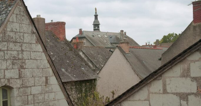 Church tower behind building roof, view from window in Behourd, France