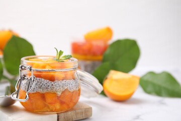 Delicious dessert with persimmon and chia seeds on table, closeup