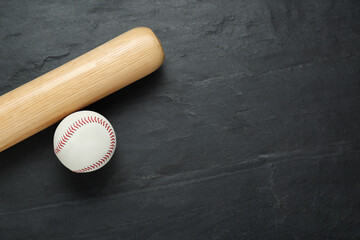 Baseball bat and ball on black background, top view with space for text. Sports equipment