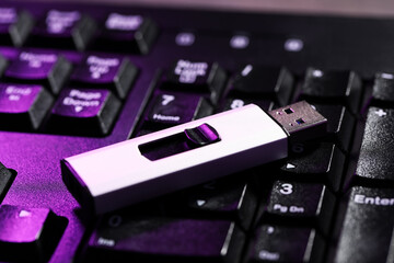 Modern usb flash drive on laptop keyboard, closeup