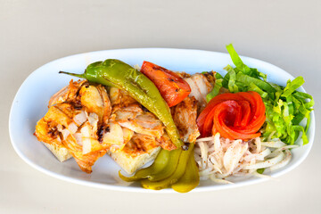 A skewered chicken kebob with grilled onions, bell peppers and delicious white meat with seasoning isolated on a white background. Tavuk sis, Tavuk izgara.