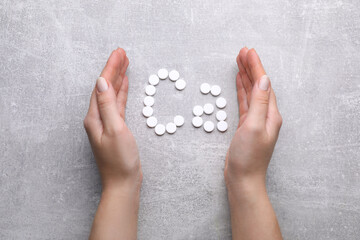 Woman and symbol Ca (Calcium) of pills on gray background, top view