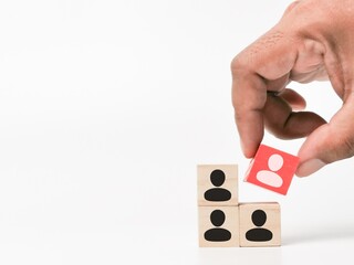 Human icons on wooden cubes. Hand pick up red color cube. Target customer or leader selection concept.