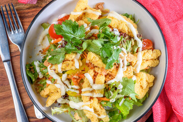 A plate of crispy Calamari Salad with lettuce, radish, lemon and avocado.
