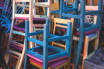 Chairs piled up in empty cafe, the end of touristic season, closed restaurant in the european streets, bad season, end of working hours, seats stacked in after hours, restaurant went bust bankrupt