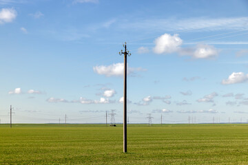 Fototapeta na wymiar High-voltage poles installed in the field for electric lines