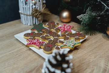 Gingerbread cookies on the plat in the hand and in the tree ready for christmas and for kids to eat holiday cookies handmade baked gingerbread cookie