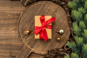 Christmas present on wooden cutting board with Christmas decorations.