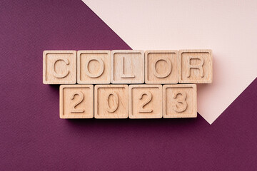 Color trend 2023 on a paper bright cherry background. Text made of wooden cubes. A palette of color trends. Beautiful burgundy color, background