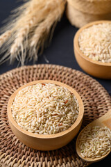 Organic Thai brown rice grain in wooden bowl, Asian healthy food ingredients