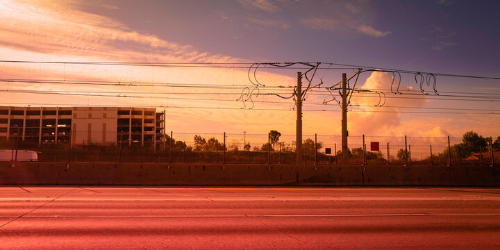 Power poles and lines on the city street at sunset, abstract geometry and urban landscape of the shapes and lines against smoggy sky in Los Angeles, California 