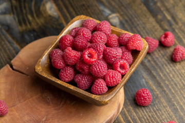 The harvest of red ripe raspberries is on the board