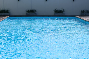 Outdoor blank swimming pool with water wave summer background