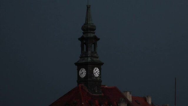 Historic tower clock with lightning strike in dark sky