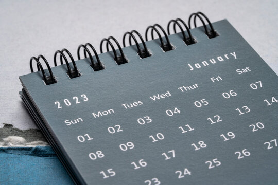 January 2023 - spiral desktop calendar  against textured paper, New Year, time and business concept