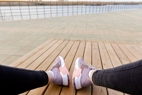 Womens Sports Shoes On Wooden Planks. White Soles Of Pink Sneakers. View From Above