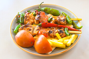 A skewered chicken kebob with grilled onions, bell peppers and delicious white meat with seasoning isolated on a white background. Tavuk sis, Tavuk izgara.