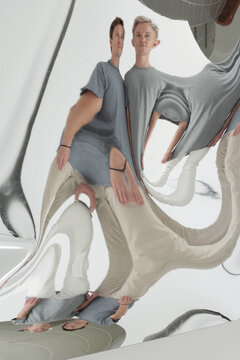 Creative shot of twin brothers totally deformed in false mirror