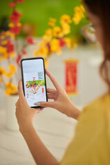 Woman Photographing Vase with Apricot Branches