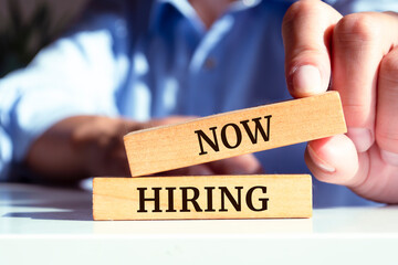 Now hiring text concept written on wooden blocks lying on a table