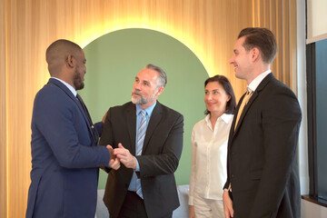 Fototapeta premium Group of multi national businesspeople having a business discussion and touching a hands together. Happy diverse nationality businessman and businesswoman making a handshake and touching a hands.