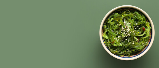 Bowl with healthy seaweed salad on green background with space for text - obrazy, fototapety, plakaty