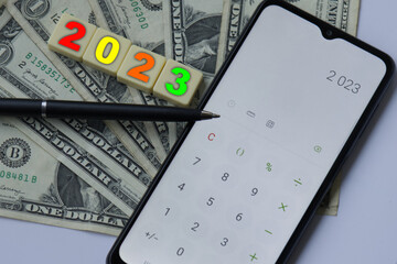 GOAL blocks with mobile, pen and one dollars bills. Money, Budget, tax, investment, financial, savings concepts. New year 2023 resolution concept. Managing budget in 2023.