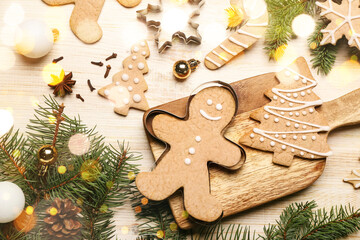 Composition with tasty Christmas gingerbread cookies and fir branches on wooden background