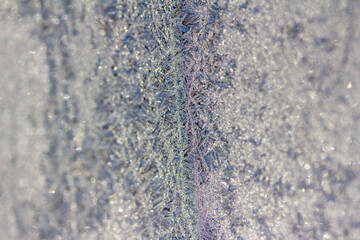 Shimmering macro abstract background of an ice frosted window pane with sparkling natural organic crystal design textures
