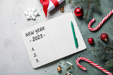 Notebook with blank to-do list for year 2023 and Christmas decor on color background