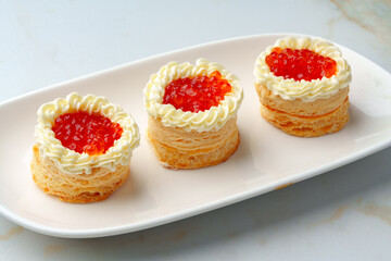 Red caviar in tartlets on white plate