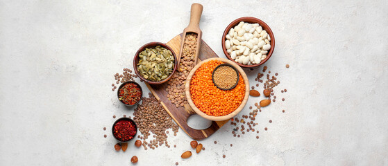 Fototapeta na wymiar Different types of lentils, haricot, pumpkin seeds and spices on light background