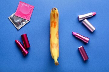 Banana with lipsticks and condoms on blue background. Sex concept