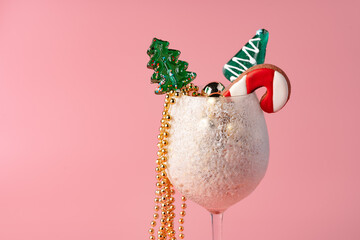 Studio shot of Christmas decorations in a glass against pink background