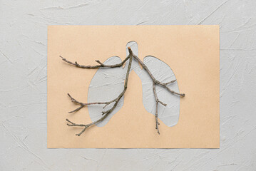 Paper lungs with tree branches on light background