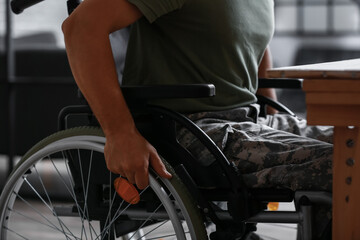 Fototapeta na wymiar Young soldier in wheelchair at home, closeup