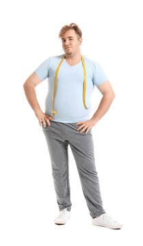 Young overweight man with measuring tape on white background