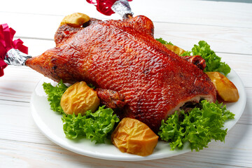 Oven baked duck with herbs and fruits on white plate