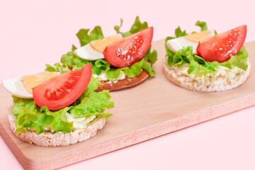Rice Cake Sandwiches with Tomato, Lettuce and Egg on Wooden Cutting Board. Easy Breakfast. Diet...