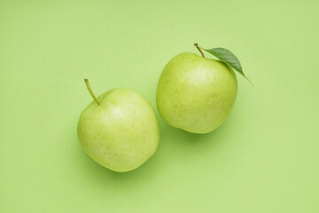 Ripe juicy apples on green background