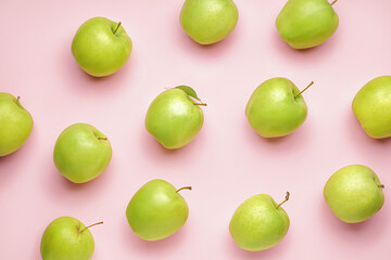 Ripe green apples on pink background