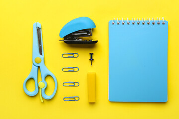 Set of stationery with stapler on yellow background