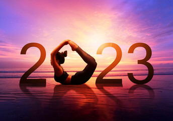 Happy new year card 2023. Silhouette of healthy girl doing Yoga One Legged Pigeon pose on tropical...