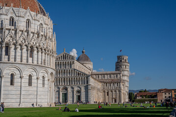 Low angle view of the baptistery, cathedral, Pisa tower and large group of people against sky.