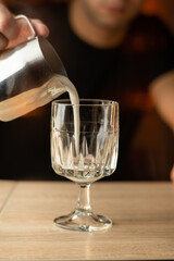 Barista pouring frothed milk into a latte glass.
