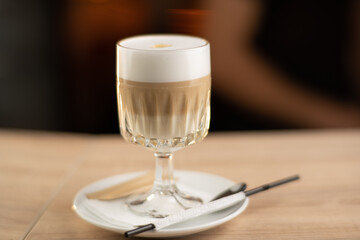 Latte macchiato in a glass glass on a dark background.