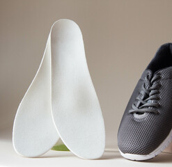 Gray sport shoes  with orthopedic insoles. Foot care products conception.