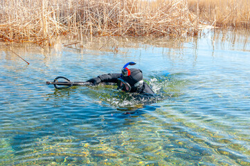 Spearfishing, men in a neoprene wetsuit in a lake with weapons for spearfishing, a harpoon diver....